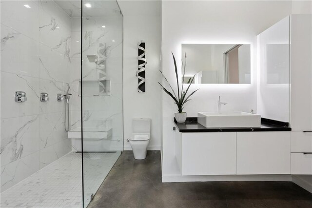 1900 Giuffrias Ave, Metairie, LA 70001 - bathroom featuring toilet, vanity, a marble finish shower, finished concrete floors, and baseboards