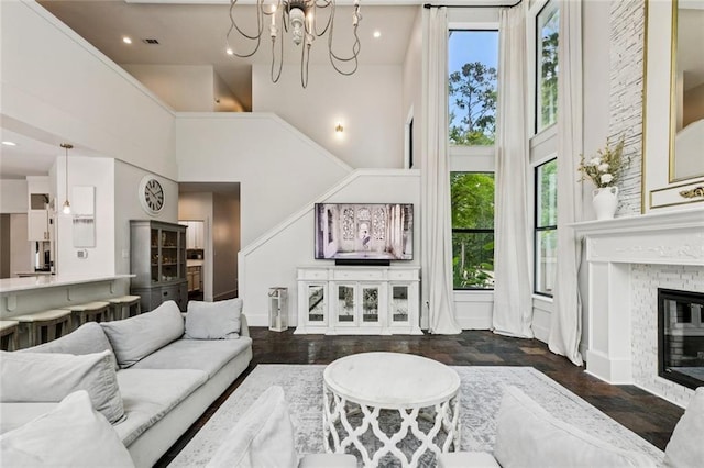 4 N Azalea Dr, Covington, LA 70433 - living area with a high ceiling, dark wood-style flooring, a chandelier, and a fireplace