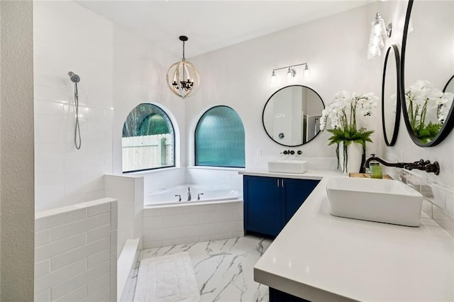 4 N Azalea Dr, Covington, LA 70433 - bathroom featuring marble look tile flooring, a garden tub, double vanity, a chandelier, and tiled shower