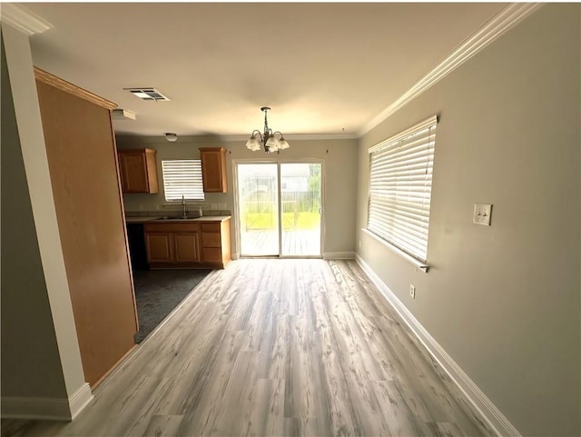 1438 Jasmine St, Mandeville, LA 70448 - unfurnished living room featuring a chandelier, baseboards, wood finished floors, a sink, and ornamental molding