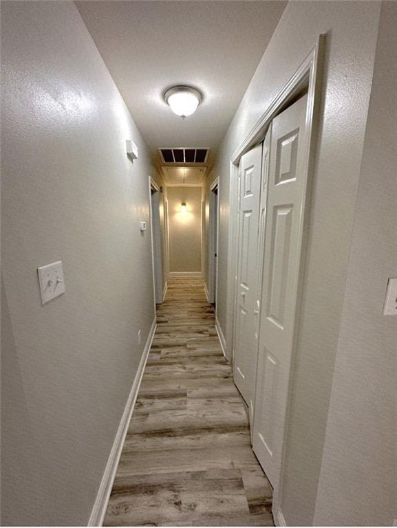 1438 Jasmine St, Mandeville, LA 70448 - hallway with light wood finished floors, attic access, and baseboards