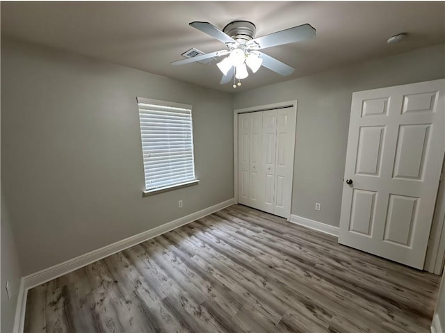 1438 Jasmine St, Mandeville, LA 70448 - unfurnished bedroom featuring baseboards, wood finished floors, a closet, and a ceiling fan