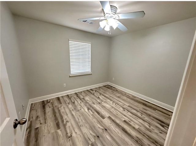 1438 Jasmine St, Mandeville, LA 70448 - spare room with light wood finished floors, baseboards, and a ceiling fan