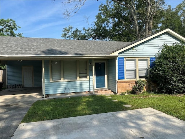 135 Bernice Ln, Ponchatoula, LA 70454 - view of front facade featuring a front lawn, a carport, brick siding, roof with shingles, and driveway