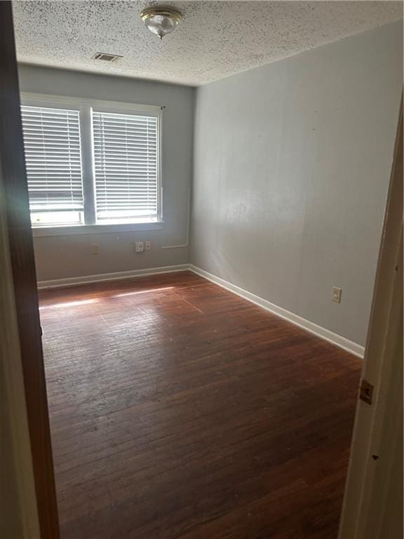 135 Bernice Ln, Ponchatoula, LA 70454 - unfurnished room featuring baseboards, a textured ceiling, and dark wood-type flooring