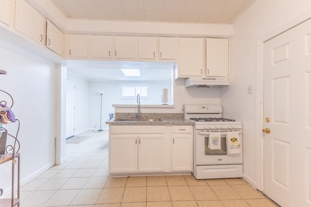 3962-64 Pauger St, New Orleans, LA 70122 - kitchen with white range with gas cooktop, a sink, under cabinet range hood, white cabinets, and light tile patterned floors