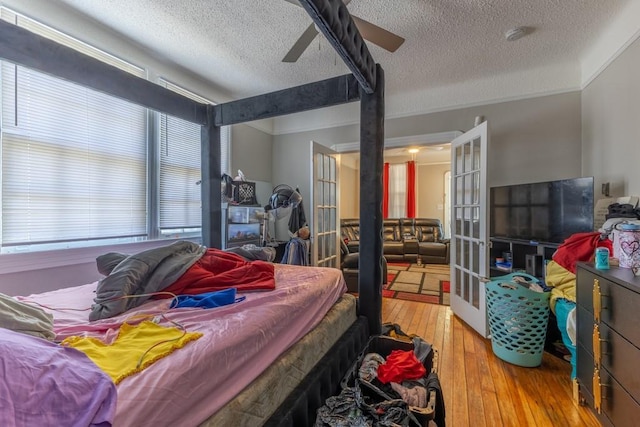 3962-64 Pauger St, New Orleans, LA 70122 - bedroom featuring a textured ceiling, french doors, hardwood / wood-style floors, crown molding, and a ceiling fan
