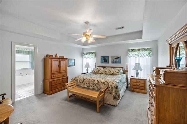 18332 Honeysuckle Dr, Ponchatoula, LA 70454 - bedroom with light colored carpet, a tray ceiling, a ceiling fan, and ensuite bathroom