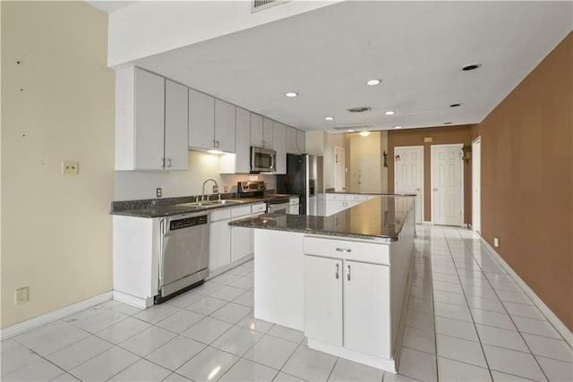 330 Morgan St Unit 201, New Orleans, LA 70114 - kitchen featuring appliances with stainless steel finishes, light tile patterned floors, a center island, recessed lighting, and white cabinetry