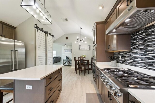 91 Rosedown Dr, Destrehan, LA 70047 - kitchen with ventilation hood, appliances with stainless steel finishes, a barn door, lofted ceiling, and backsplash