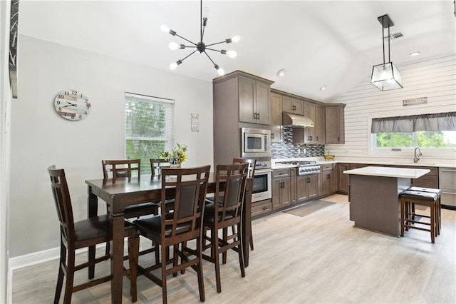 91 Rosedown Dr, Destrehan, LA 70047 - dining space with vaulted ceiling, light wood-style floors, a chandelier, baseboards, and recessed lighting