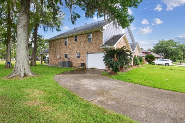 91 Rosedown Dr, Destrehan, LA 70047 - view of side of home with driveway, an attached garage, central air condition unit, brick siding, and a yard