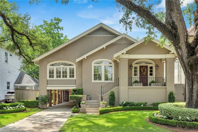 324 Fairway Dr, New Orleans, LA 70124 - view of front facade featuring brick siding, driveway, stucco siding, a front lawn, and stairway