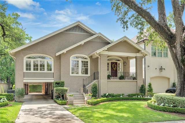 324 Fairway Dr, New Orleans, LA 70124 - view of front facade featuring stucco siding, a carport, brick siding, driveway, and covered porch