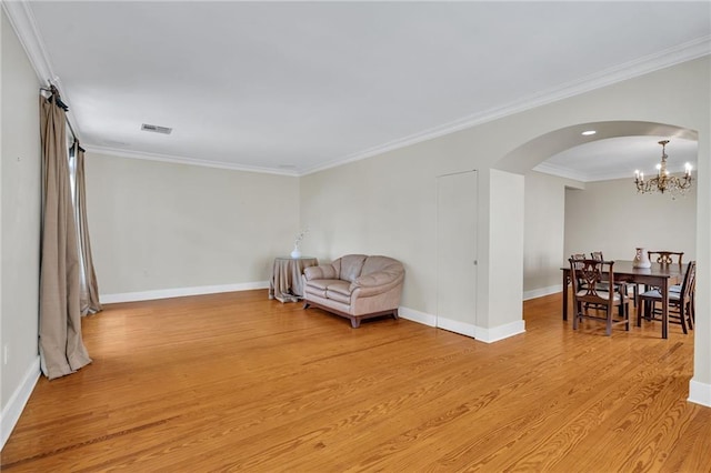 324 Fairway Dr, New Orleans, LA 70124 - living area featuring light wood-style floors, arched walkways, a chandelier, baseboards, and crown molding
