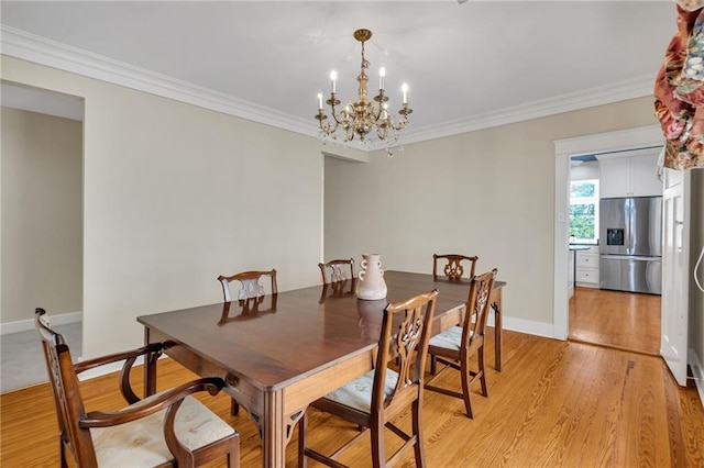 324 Fairway Dr, New Orleans, LA 70124 - dining area featuring a chandelier, crown molding, light wood-style floors, and baseboards