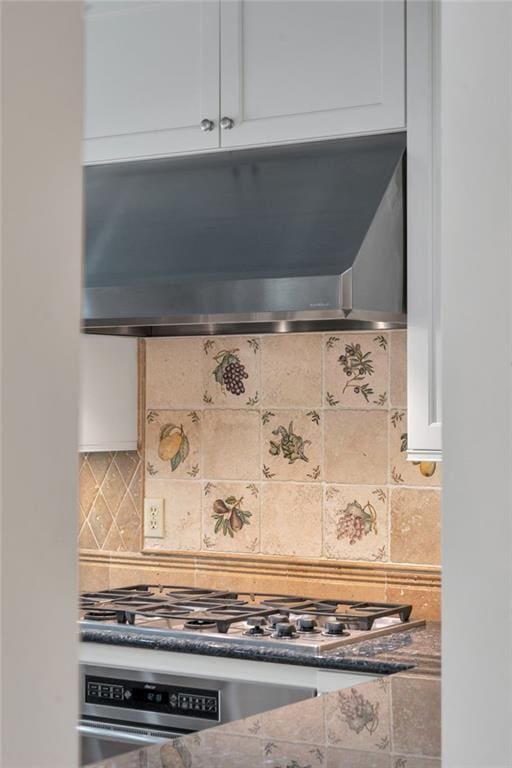 324 Fairway Dr, New Orleans, LA 70124 - kitchen view of extractor fan, stainless steel appliances, backsplash, and white cabinets