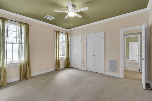 324 Fairway Dr, New Orleans, LA 70124 - unfurnished bedroom with light colored carpet, multiple closets, ornamental molding, baseboards, and a ceiling fan