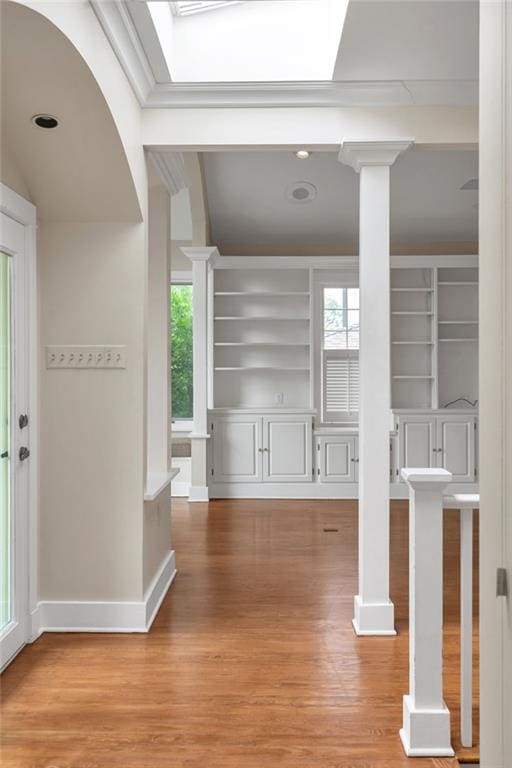 324 Fairway Dr, New Orleans, LA 70124 - hall with built in shelves, light wood finished floors, healthy amount of natural light, and decorative columns