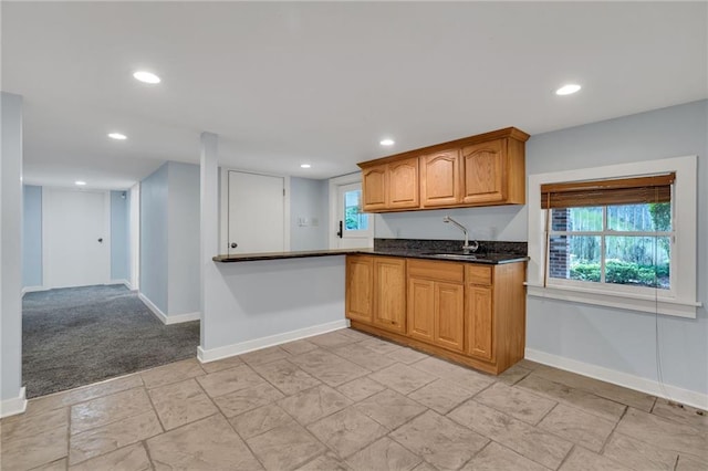 324 Fairway Dr, New Orleans, LA 70124 - kitchen featuring a sink, baseboards, recessed lighting, brown cabinets, and dark stone countertops