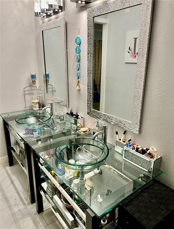 120 Whisperwood Blvd, Slidell, LA 70458 - bathroom with a textured wall, marble finish floors, and vanity