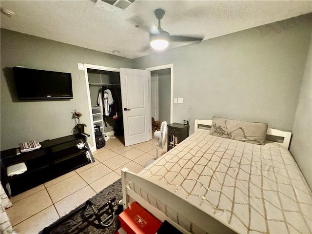 120 Whisperwood Blvd, Slidell, LA 70458 - bedroom featuring light tile patterned floors, a textured ceiling, a closet, and a ceiling fan