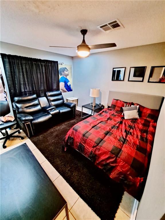 120 Whisperwood Blvd, Slidell, LA 70458 - tiled bedroom featuring a ceiling fan and a textured ceiling