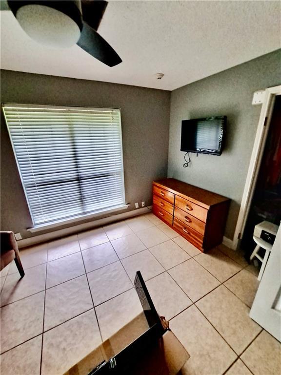 120 Whisperwood Blvd, Slidell, LA 70458 - unfurnished living room with light tile patterned floors, ceiling fan, baseboards, and a textured ceiling