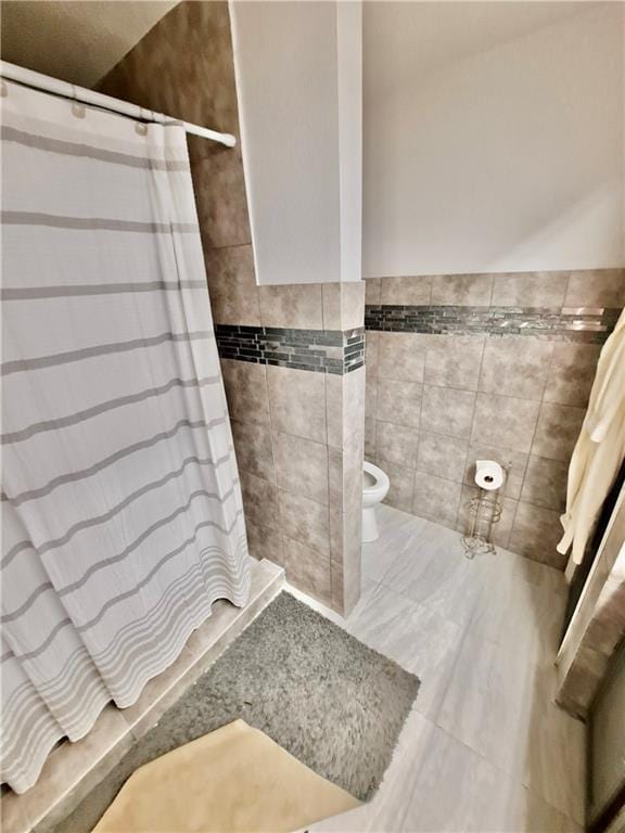 120 Whisperwood Blvd, Slidell, LA 70458 - full bathroom featuring tile walls, a tile shower, tile patterned flooring, and a wainscoted wall
