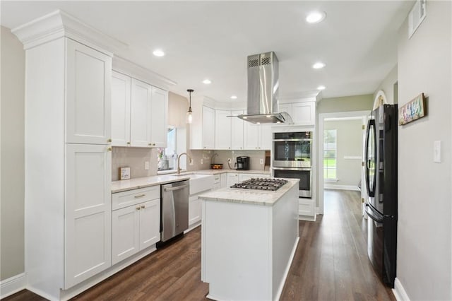 2351 Ormond Blvd, Destrehan, LA 70047 - kitchen featuring stainless steel appliances, island exhaust hood, baseboards, backsplash, and a kitchen island