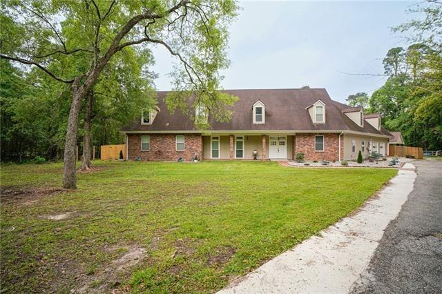 115 Devereux Dr, Slidell, LA 70461 - cape cod-style house featuring a front yard, brick siding, and covered porch
