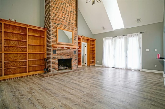115 Devereux Dr, Slidell, LA 70461 - unfurnished living room with high vaulted ceiling, wood finished floors, a brick fireplace, and baseboards