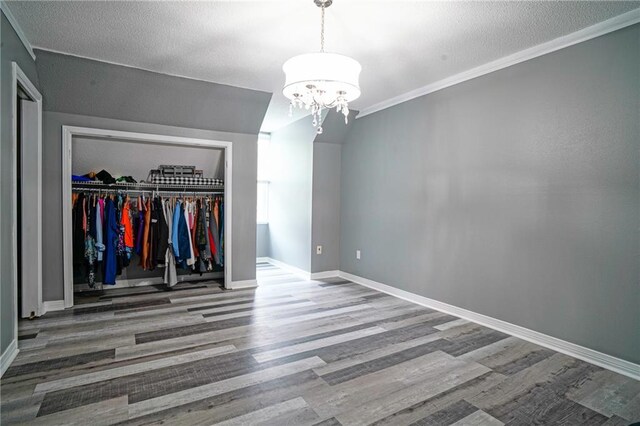 115 Devereux Dr, Slidell, LA 70461 - unfurnished bedroom featuring a closet, wood finished floors, a chandelier, baseboards, and crown molding
