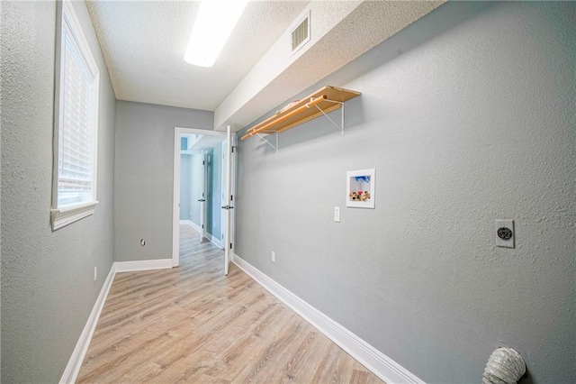115 Devereux Dr, Slidell, LA 70461 - laundry area with washer hookup, electric dryer hookup, light wood-type flooring, baseboards, and a textured wall