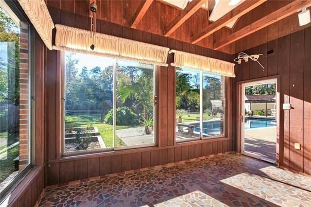 115 Devereux Dr, Slidell, LA 70461 - unfurnished sunroom featuring stone floors and wood walls