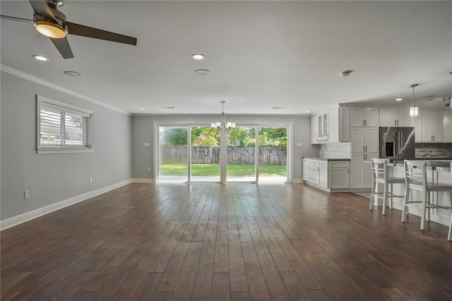9509 Robin Ln, River Ridge, LA 70123 - unfurnished living room featuring ceiling fan, crown molding, dark wood finished floors, baseboards, and a chandelier