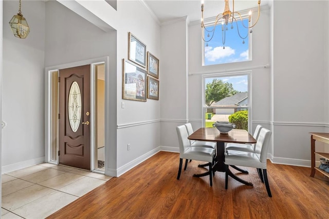 1833 Octavia Dr, Mandeville, LA 70448 - entrance foyer featuring a chandelier, a high ceiling, baseboards, crown molding, and light wood-style flooring