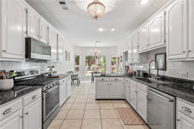 1833 Octavia Dr, Mandeville, LA 70448 - kitchen with stainless steel appliances, a chandelier, a sink, white cabinetry, and recessed lighting