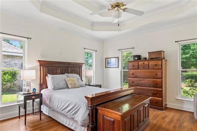 1833 Octavia Dr, Mandeville, LA 70448 - bedroom featuring a raised ceiling, multiple windows, wood finished floors, and ornamental molding