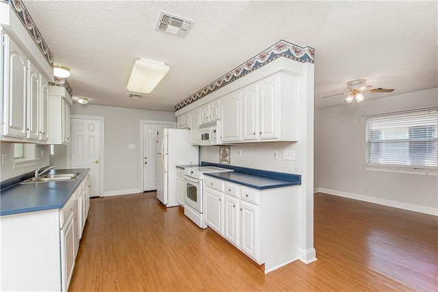 413 Moonraker Dr, Slidell, LA 70458 - kitchen featuring white appliances, a sink, dark countertops, white cabinetry, and a textured ceiling