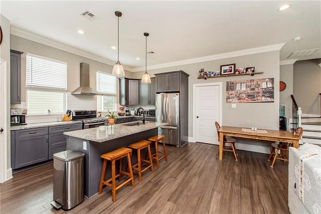 5 Leeward Ct, New Orleans, LA 70131 - kitchen with stainless steel appliances, wall chimney exhaust hood, dark wood-style floors, a kitchen bar, and light stone countertops