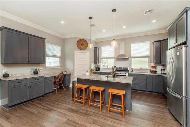 5 Leeward Ct, New Orleans, LA 70131 - kitchen with freestanding refrigerator, wall chimney range hood, stove, a kitchen breakfast bar, and light stone counters