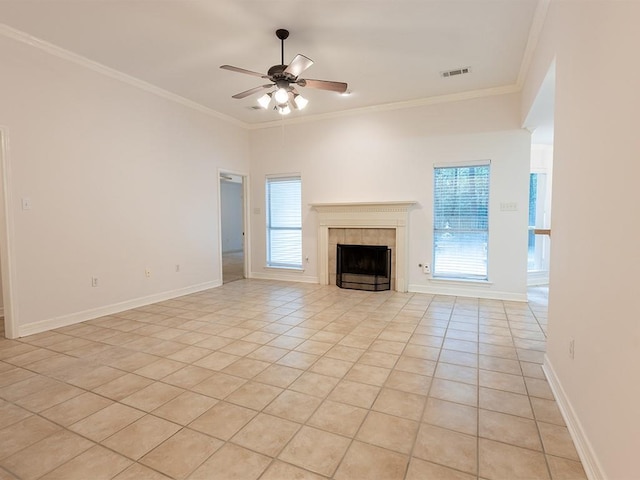 653 Beaulieux St, Mandeville, LA 70448 - unfurnished living room featuring light tile patterned flooring, ornamental molding, a ceiling fan, a tiled fireplace, and baseboards