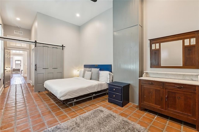 222527 Iberville St, New Orleans, LA 70119 - bedroom featuring a high ceiling, light tile patterned flooring, a barn door, and a closet