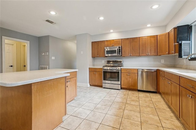 4616 Kawanee Ave, Metairie, LA 70006 - kitchen with stainless steel appliances, a sink, brown cabinets, recessed lighting, and light countertops