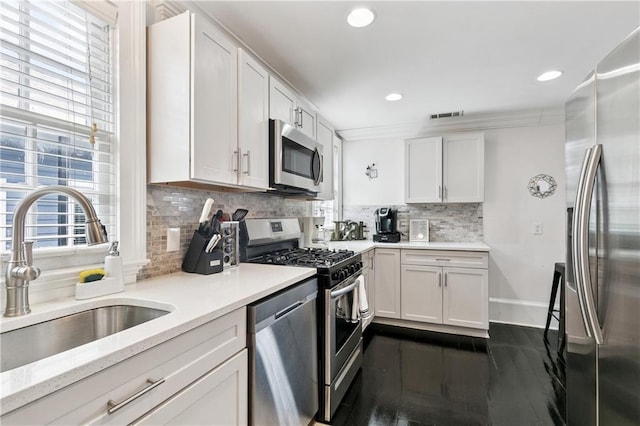 1030 Kerlerec St Unit 4, New Orleans, LA 70116 - kitchen featuring stainless steel appliances, a sink, backsplash, white cabinets, and recessed lighting