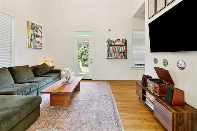6945 Milne Blvd, New Orleans, LA 70124 - living area featuring light wood-style floors, baseboards, and a high ceiling