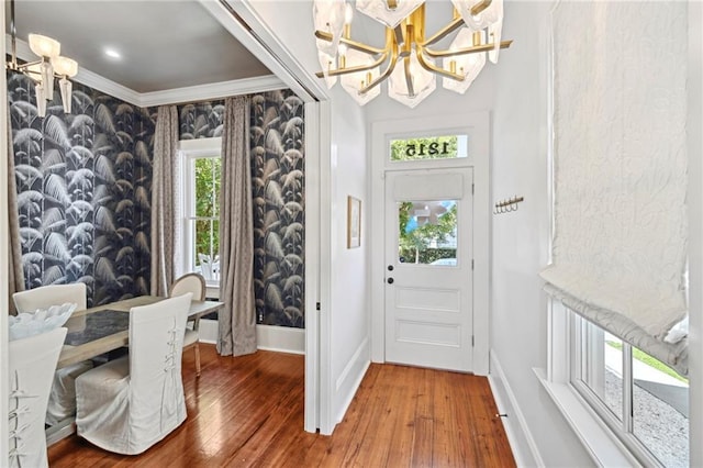 1215 Saint Andrew St, New Orleans, LA 70130 - foyer featuring a chandelier, wood-type flooring, baseboards, and crown molding