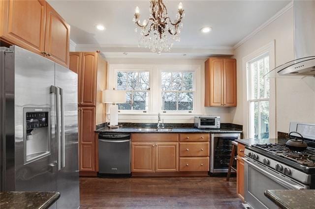 1510 Camp St, New Orleans, LA 70130 - kitchen featuring appliances with stainless steel finishes, wine cooler, wall chimney range hood, ornamental molding, and a chandelier