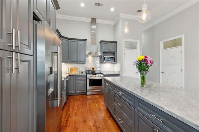 4823 Dreux Ave, New Orleans, LA 70126 - kitchen featuring stainless steel appliances, wall chimney exhaust hood, gray cabinetry, decorative backsplash, and crown molding